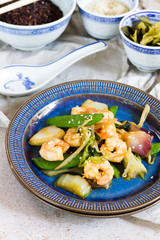 Stir fry with shrimps. Oriental food. Blue plate, chineese bowls.