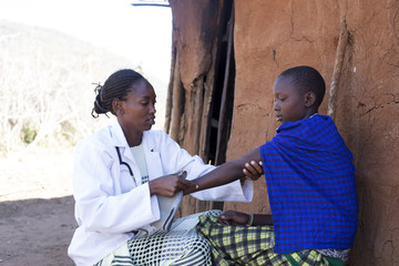 Doctor examining female patient. Kenya, Africa