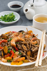plate of Asian buckwheat noodles with seafood and vegetables, vertical