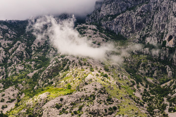 Wild mountain range and clouds on the hillside near Kotor bay in Montenegro. Wilderness montenegrin landscape. Trekking and hiking place.