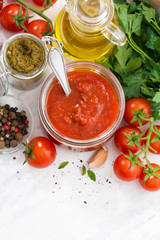 tomato sauce, pesto and ingredients on a white background, vertical, top view