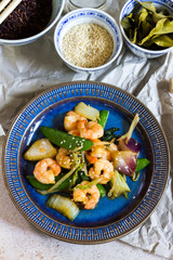 Stir fry with shrimps. Oriental food. Blue plate, chineese bowls.