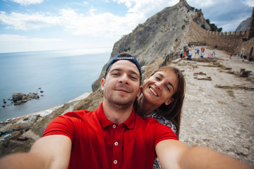 Fototapeta na wymiar Beautiful couple making selfie in instagram in Sudak, Russia