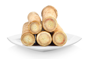 Fresh Burdock roots in white plate on white background