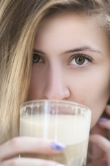 Portrait of a beautiful girl drinking coffee, close-up