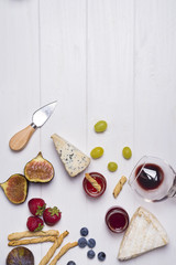 Fototapeta na wymiar Different types of cheeses with wine glass and fruits
