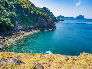 Seascape background of stone, tree on island with clear blue sea.