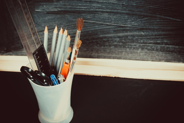 Old blackboard with chalk, books, a globe and a pencil. A beautiful backdrop for education, a free space for your text. Back to school. Shallow DOF.