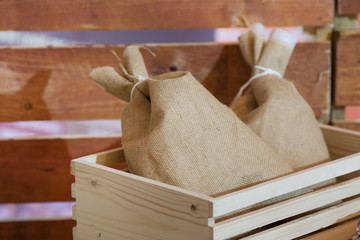 Coffee beans in sack bag on brown wooden background