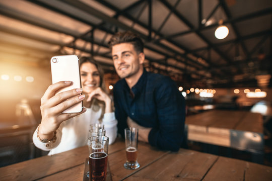 Young couple sitting in the bar and taking a selfie