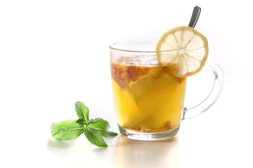 Cup of healthy drink of seabuckthorn, lemon and mint on white background.