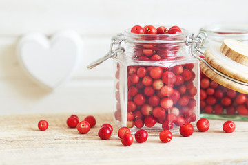 Fototapeta na wymiar Fresh ripe cranberries in glass jar. Copy space 