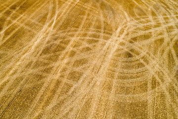 Aerial top flat view of a field tracks after harvesting from a drone