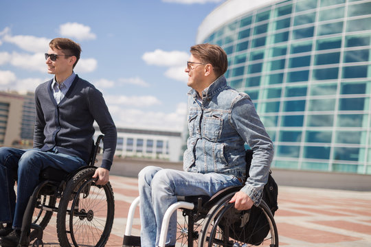 Shot of a young man spending time in a park with his friend using a wheelchair