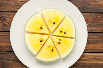 yellow watermelon slices on dark old wooden background top view