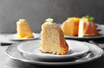 Plate with slice of delicious citrus cake on table