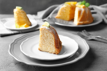 Plate with slice of delicious citrus cake on table