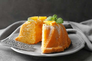 Delicious sliced citrus cake with orange on grey table
