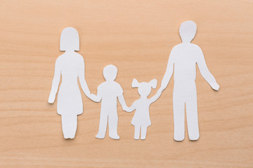 Paper silhouette of family on wooden background. Life insurance concept