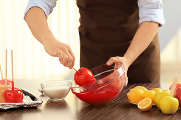 Young woman preparing toffee apples in kitchen