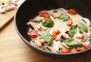 Frying pan with ingredients for delicious turkey tetrazzini on table