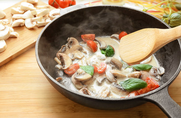 Frying pan with ingredients for delicious turkey tetrazzini on board