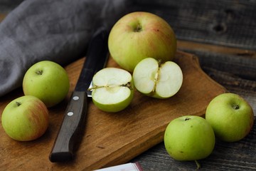 Fresh green rustic apples on a grey background
