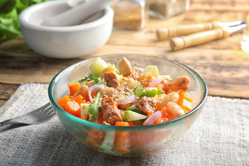 Bowl with delicious carrot salad on table