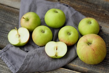 Fresh green rustic apples on a grey background