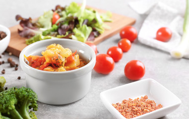 Composition with homemade stew, vegetables and spices on light background