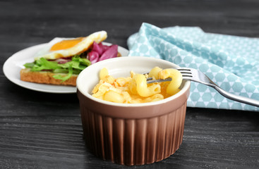 Delicious pasta with cheese in casserole dish on table