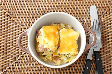 Pot with nutritious casserole on table mat
