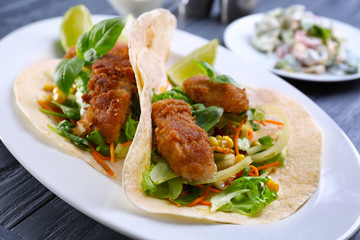 Delicious fish tacos on white plate, close up