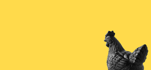 black color painted female bantum plaster sculpture on yellow background, copy space on left