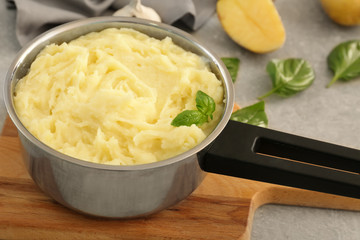 Pot with mashed potatoes on table