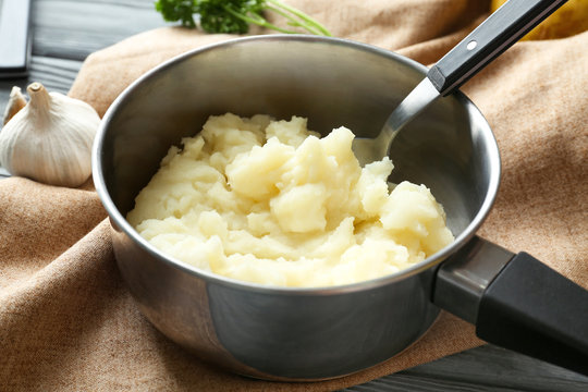 Pot with mashed potatoes on table