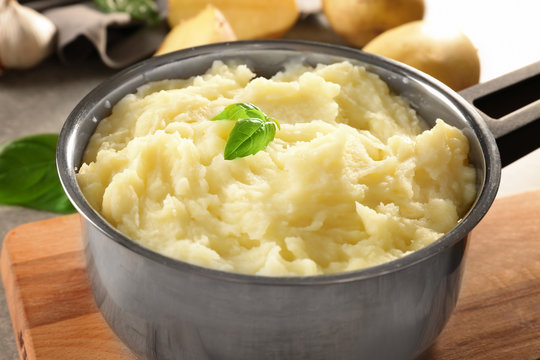 Pot with mashed potatoes on table, closeup