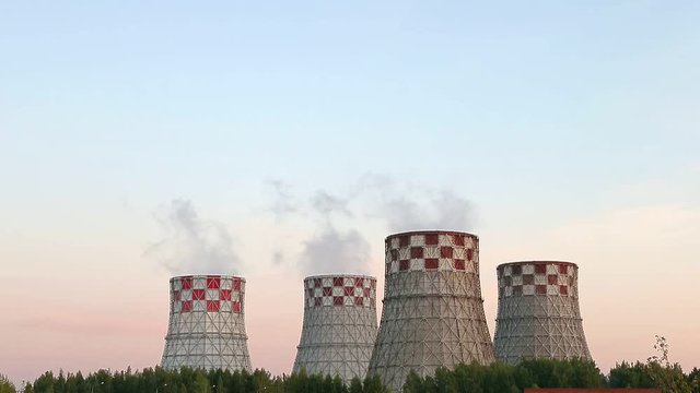 Cogeneration power plant in city. Thermal Power Station chimney smoke sky. Sunset landscape. Combined heat and power plant near megapolis. Chimney-stalk and ecology problem on Earth. Heat electricity.