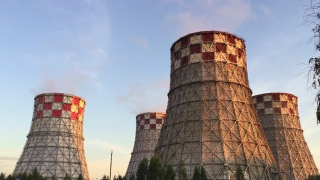 Cogeneration power plant in city. Thermal Power Station chimney smoke sky. Close-up. Sunset landscape. Combined heat power plant near megapolis. Chimney-stalk and ecology on Earth. Heat electricity.