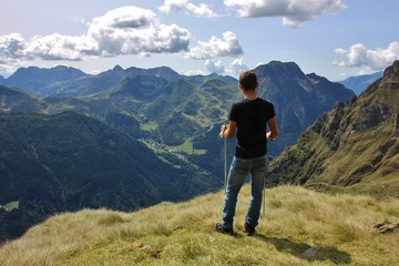 Hiker enjoying the view on Orobie Alps over Seriana Valley, Bergamo, Italy