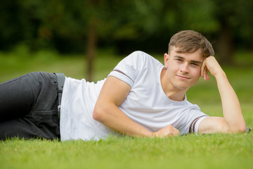 Teenage boy laying on grass on a summers day