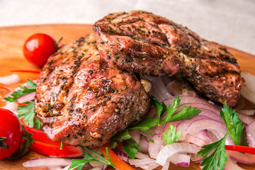 Appetizing fried chicken thighs, decorated with tomatoes and onions. Horizontal frame