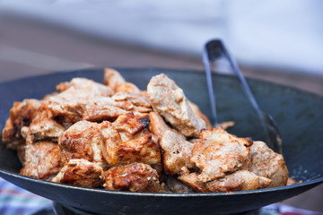 Grilled meat is prepared in the wok