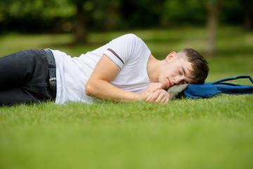 Teenage boy laying on grass on a summers day