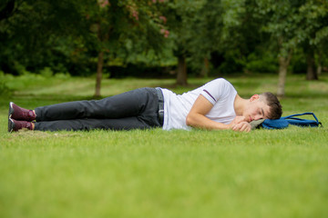 Fototapeta na wymiar Teenage boy laying on grass on a summers day