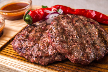 Appetizing fried beef cutlet, decorated with herbs, pepper, with sauce. Horizontal frame