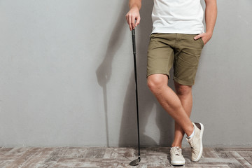 Cropped image of golfer posing with club