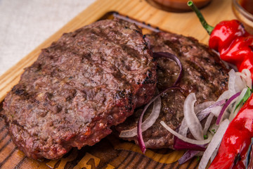 Appetizing fried beef cutlet, decorated with herbs, pepper, with sauce. Horizontal frame
