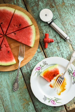 Fresh watermelon as vegan pizza with pizza knife and tire-bouchon on shabby wooden table