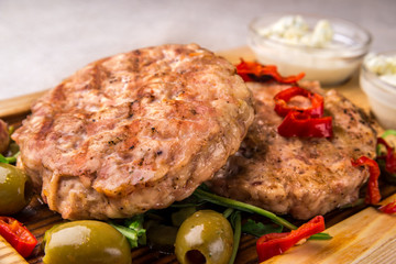 Appetizing fried chicken cutlet, decorated with olives, pepper, with sauce. Horizontal frame
